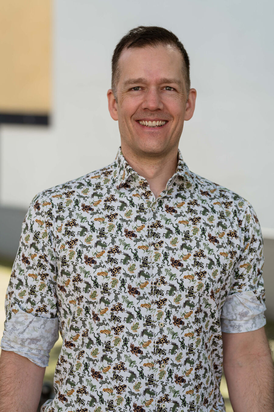 Portrait of Mathias, smiling, in a shirt with a frog pattern
